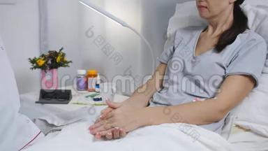 医生审问躺在医院病房床上的病人。 医生测量病人的体温。